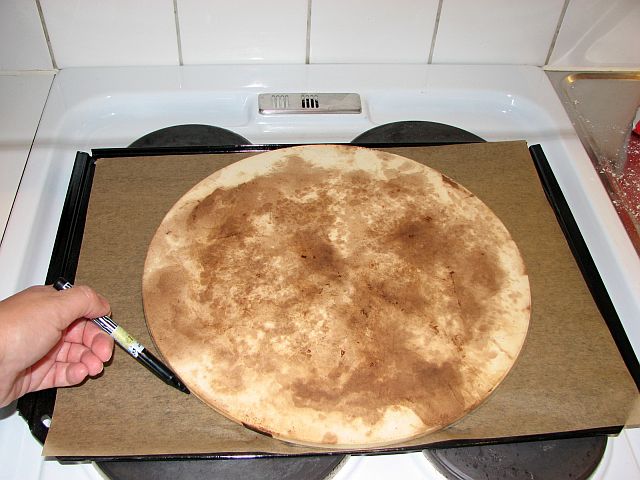 Markera pizzastenens konturer på bakplåtspappret.