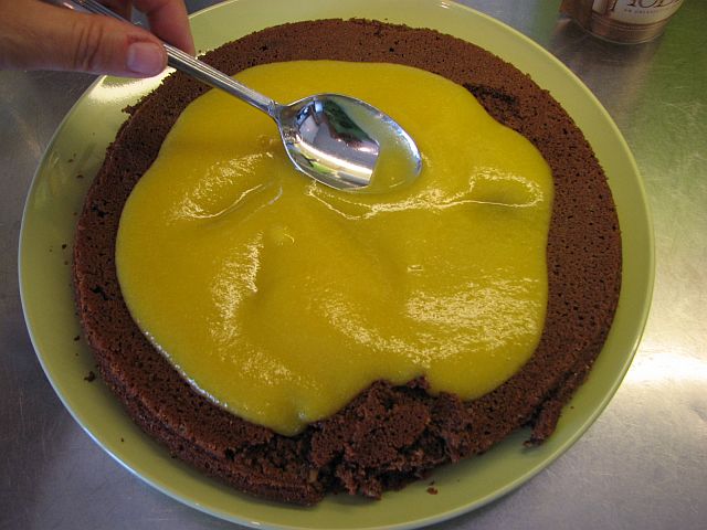 Bred persikogelén över chokladkakan