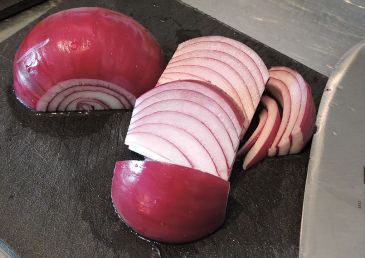 Skala rödlöken och skär i klyftor