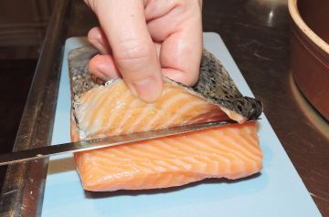 Skär skinnet av laxfilen