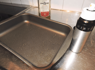 Spreja olivolja i en ugnsfast form