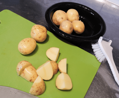 Skrubba potatis skär i bitar